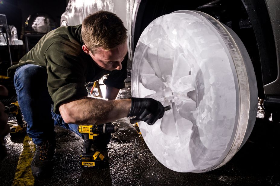 Ice sculptors carefully install their handcrafted wheels onto the car after spending up to 36 hours on each one.