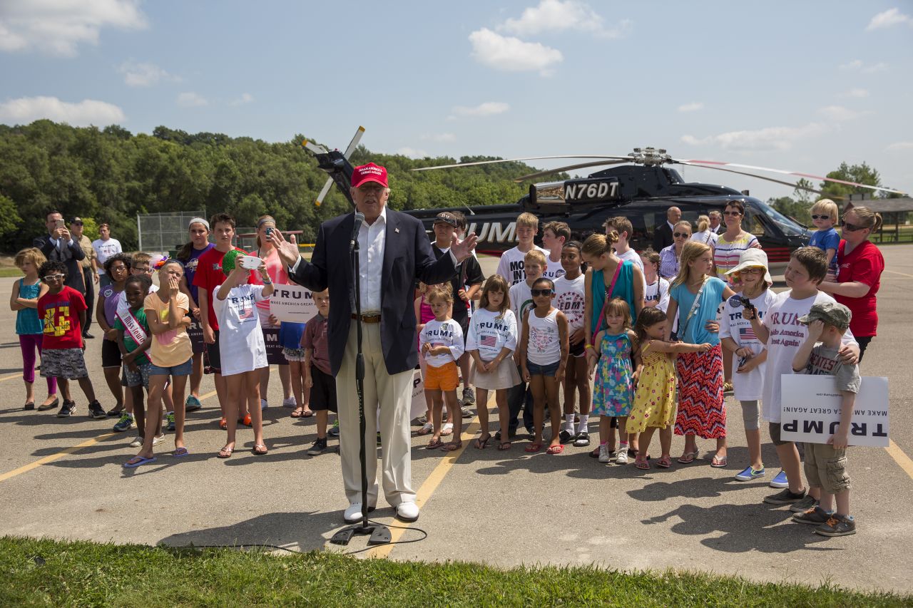 Trump speaks with reporters after arriving at the Iowa State Fair in Des Moines on August 15. Trump gave children rides on his helicopter. 