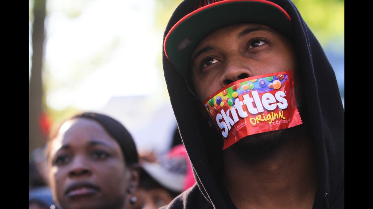 College student Jajuan Kelley covers his mouth with a Skittles wrapper as he stands in a crowd of thousands rallying at the Georgia State Capitol in Atlanta in memory of Trayvon Martin in March 2012.