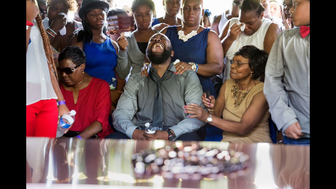 Michael Brown Sr. yells out as the casket of his son Michael is lowered into the ground during his funeral at St. Peters Cemetery in August 2014 in St. Louis.