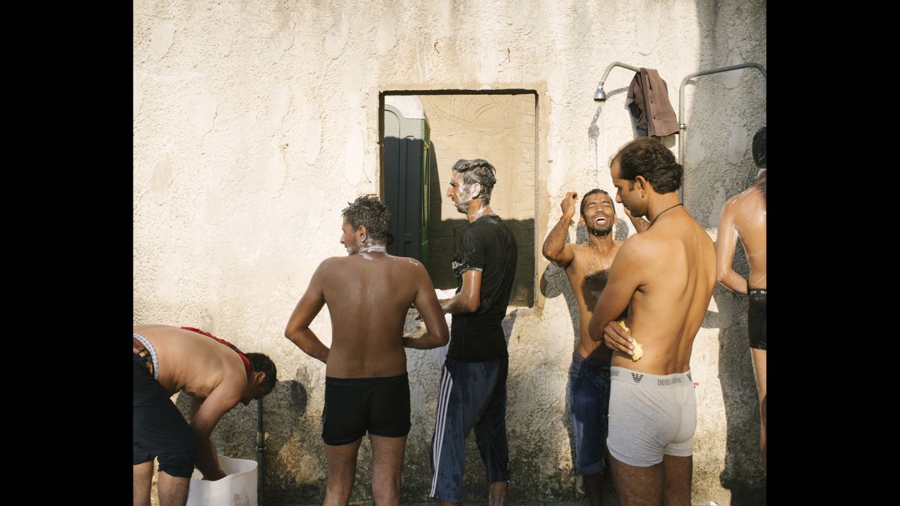 Migrants shower at the abandoned Hotel Captain Elias.