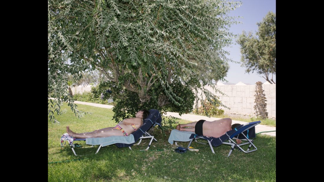 Tourists enjoy their holiday in the shade.
