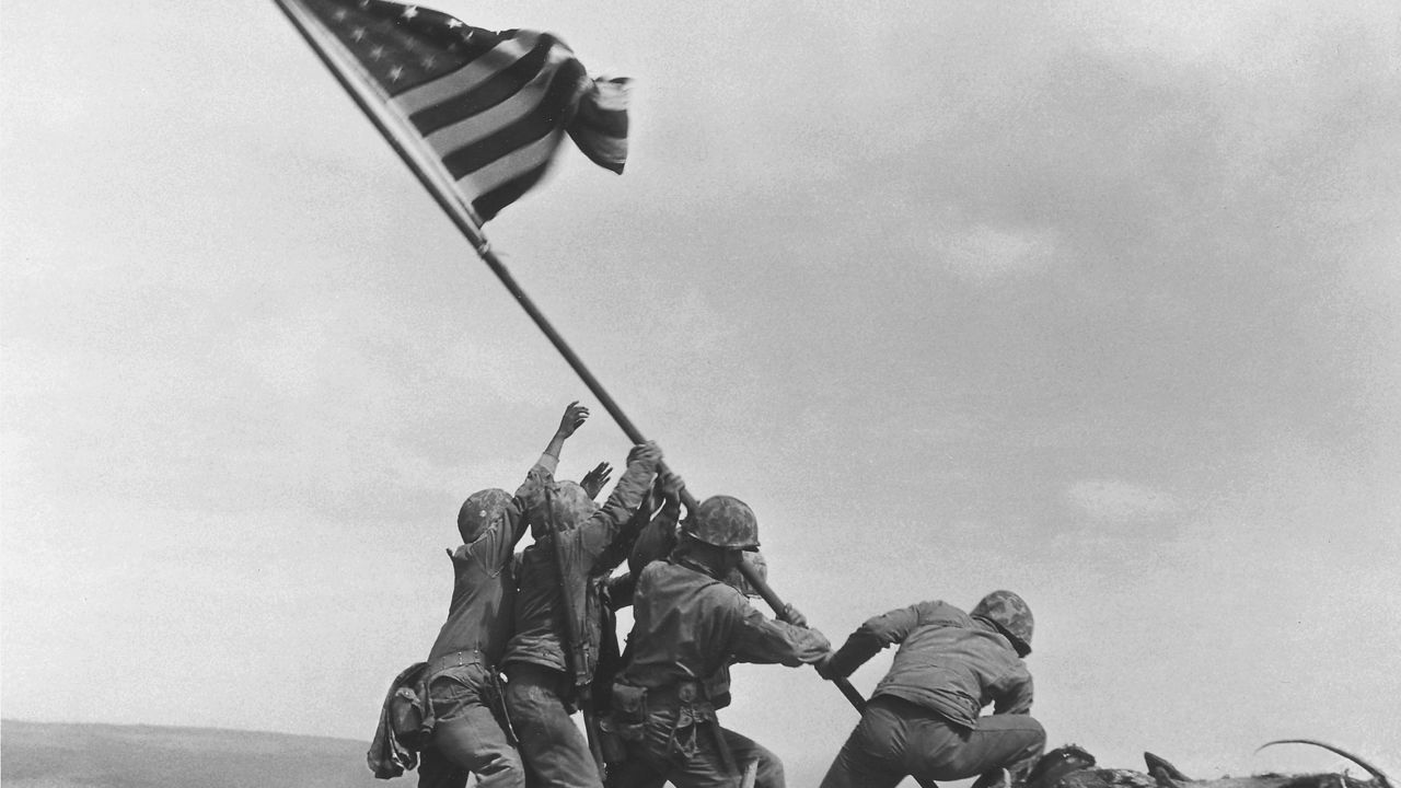 U.S. Marines of the 28th Regiment, 5th Division, raise the American flag atop Mt. Suribachi, Iwo Jima, on Feb. 23, 1945. Strategically located only 660 miles from Tokyo, the Pacific island became the site of one of the bloodiest, most famous battles of World War II against Japan.  (AP Photo/Joe Rosenthal)