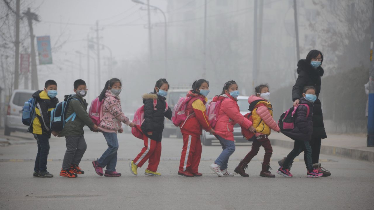 Schoolchildren wearing face masks walk across a street in Jinan, China, amid heavy air pollution in 2015.