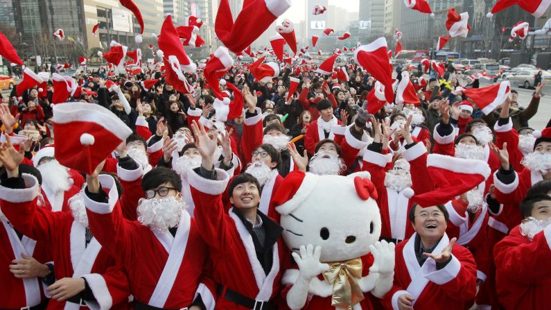 South Koreans wearing Santa Claus outfits promote a Christmas charity event in Seoul, South Korea, on Thursday.