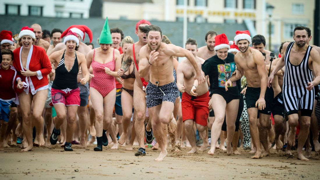 People run for the water at Exmouth Beach in Devon, England, during the Exmouth Christmas Day Swim on Friday, December 25.