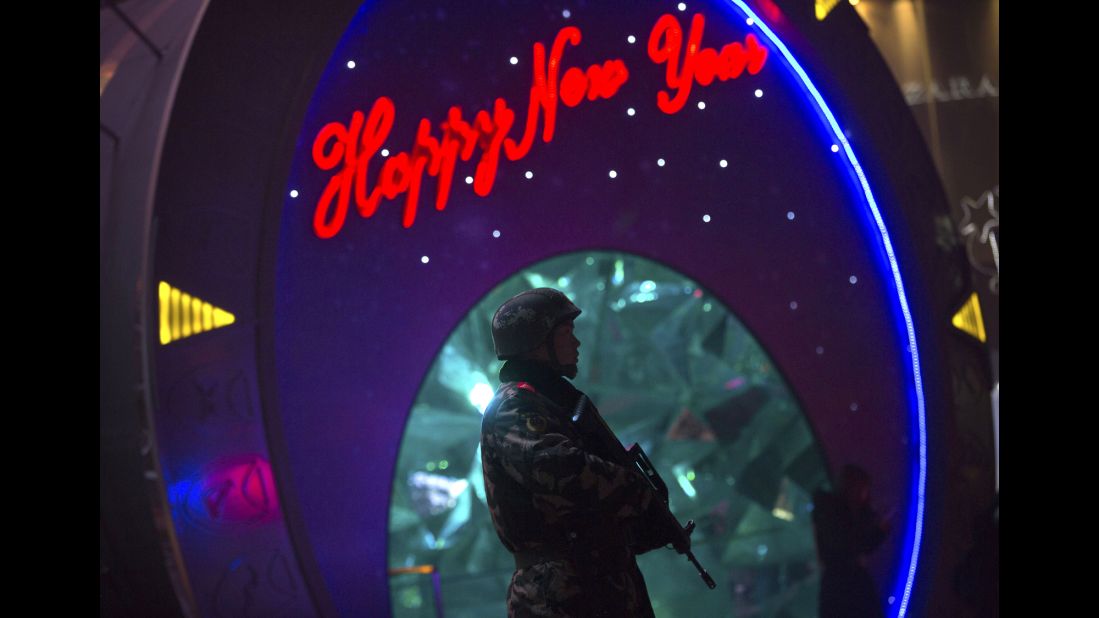 An armed police officer stands guard outside a shopping mall in Beijing on December 25. Security remained elevated in parts of Beijing on Friday, a day after the embassies of the United States and other countries in China warned of potential threats to Westerners around the Christmas holiday.