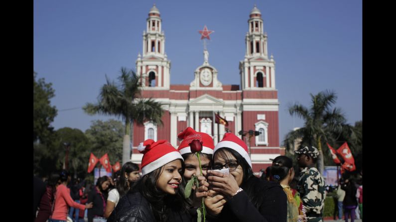 Girls look at photos after taking selfies in front of the Sacred Heart Cathedral in New Delhi on December 25.