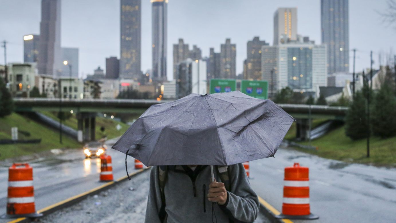 A man walks near downtown Atlanta in the rain on Thursday, December 24. Georgia Gov. Nathan Deal declared a state of emergency in three north Georgia counties amid the strong storms. 