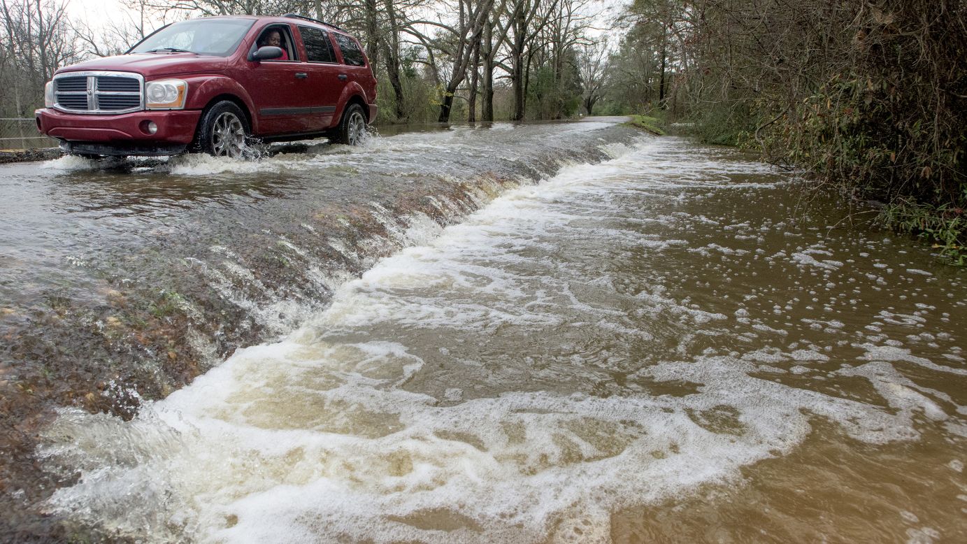 A vehicle drives along a flooded section of Hayneville Road in west Montgomery, Alabama, on Christmas morning.