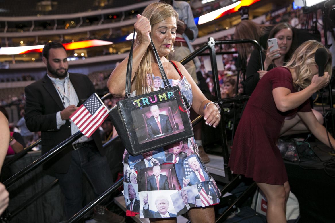A woman wears a dress covered in printouts of Donald Trump's face during a campaign rally in Dallas on September 14.