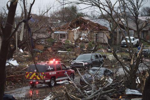 An emergency vehicle drives through a neighborhood in Rowlett, Texas, on Sunday, December 27. Crews were scouring debris for victims and assessing damage.