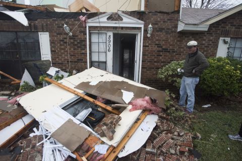 Michael Downard stands outside his house in Rowlett the morning after it was struck by a tornado.