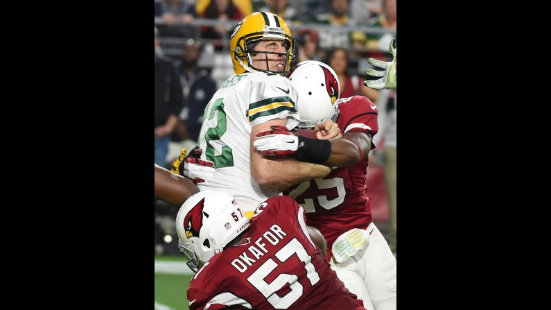 Green Bay quarterback Aaron Rodgers is sacked by Arizona's Alex Okafor and Jerraud Powers during an NFL game in Glendale, Arizona, on Sunday, December 27. Rodgers was sacked eight times as the Cardinals rolled to a 38-8 victory.