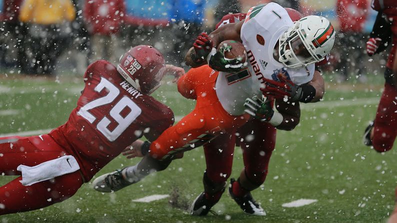 Snow falls in the ironically named Sun Bowl as Miami running back Mark Walton dives for a touchdown on Saturday, December 26. Washington State won the game 20-14 in El Paso, Texas. 