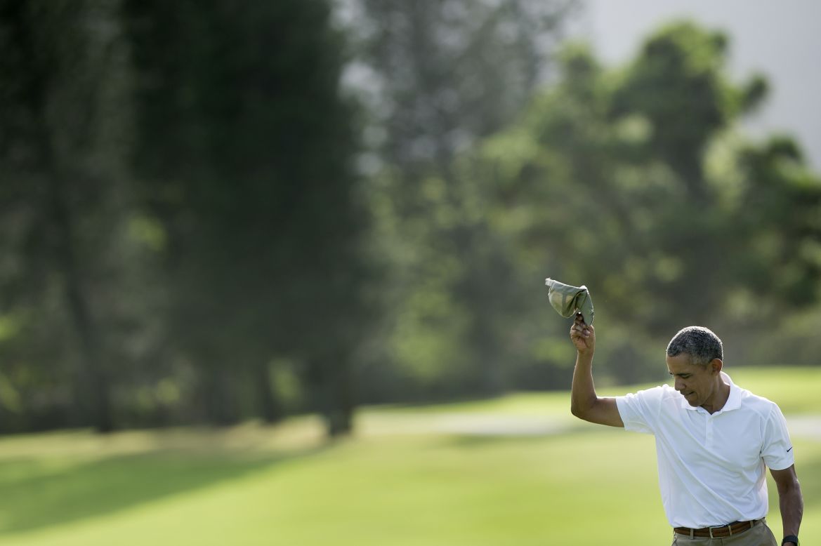 Obama tips his hat after finishing the 18th hole at the Mid Pacific Country Club golf course.