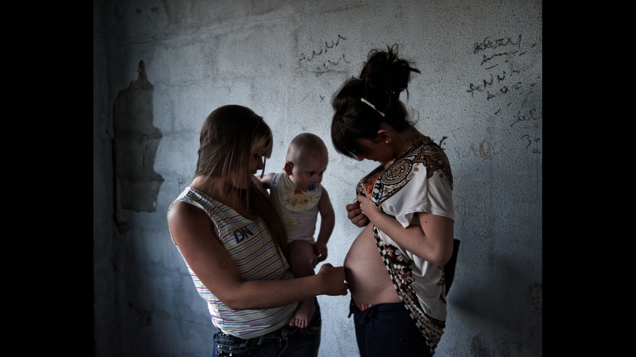 Virna, left, talks to Alessandra, 15, in the Naples neighborhood of Via Stadera. The two grew up together. Alessandra is a few months pregnant.