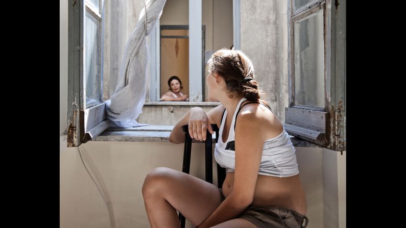 Carla talks to a neighbor at the window.