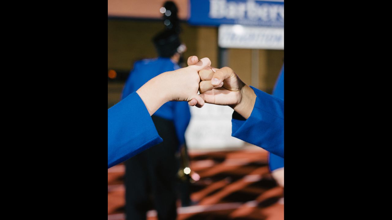Flute players from the Barbers Hill High School Marching Band perform the "flute handshake" before a performance.