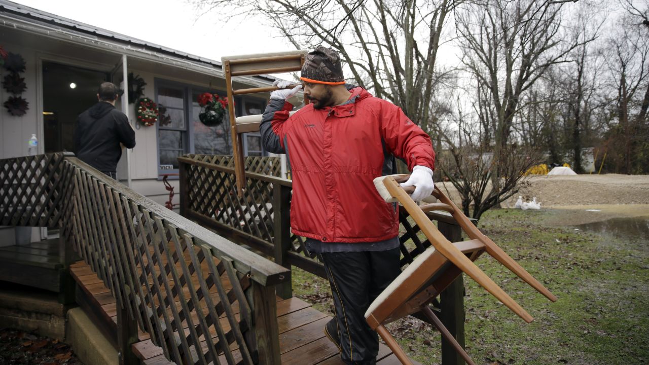 Men help move furniture out of a gift shop as a precaution on December 28 in Kimmswick.