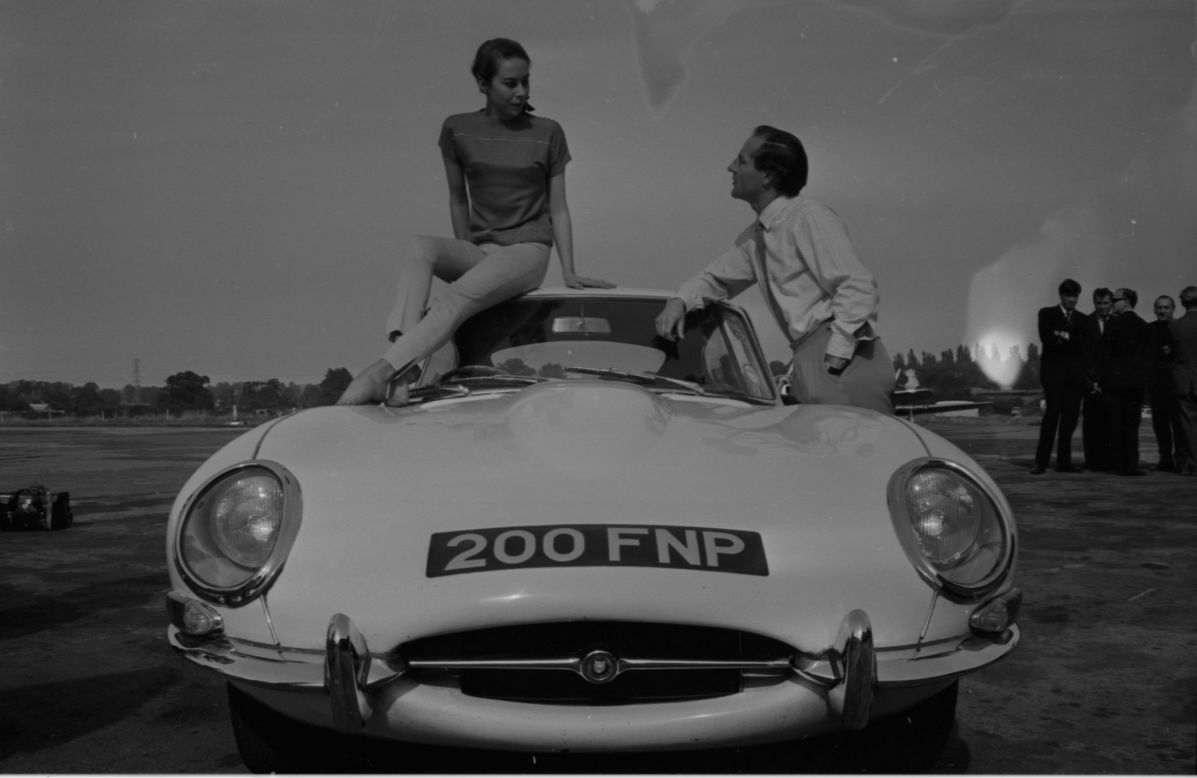 An icon of the Swinging Sixties arrives with the E-Type Jaguar, seen here with racing driver Innes Ireland and Kathy Keeton.