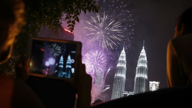 People watch New Year's fireworks in Kuala Lumpur, Malaysia.