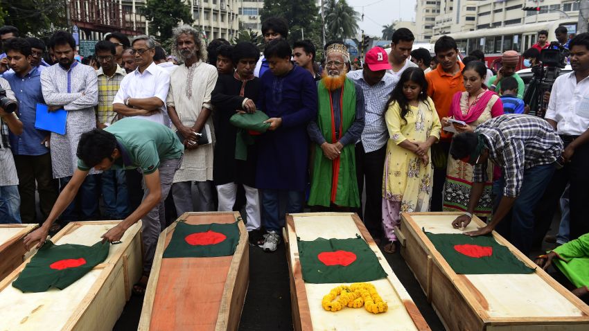 Bangladeshi activists place national flags on mock coffins, that symbolize the deaths of secular publishers and bloggers, in Dhaka on November 5, 2015.