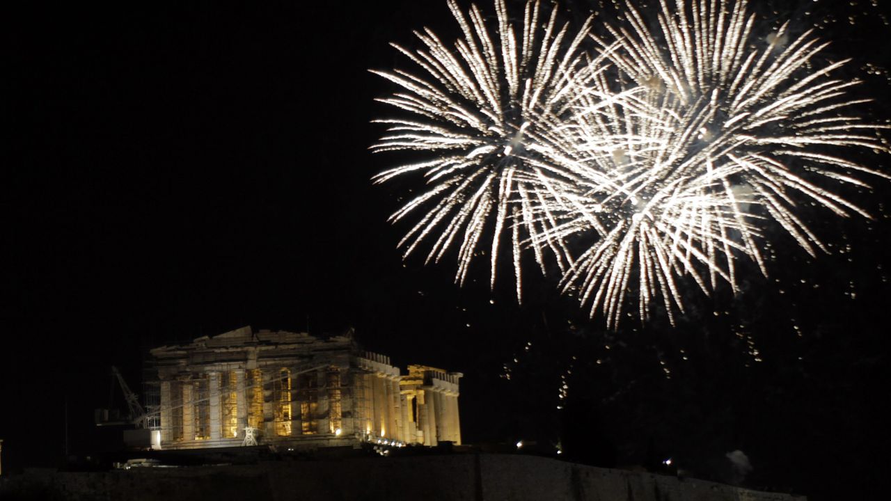 Fireworks illuminate the sky over the hill of the Acropolis in Athens, Greece.