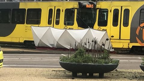One section of the tram is shielded by a tarpaulin, which is believed to be covering a body.