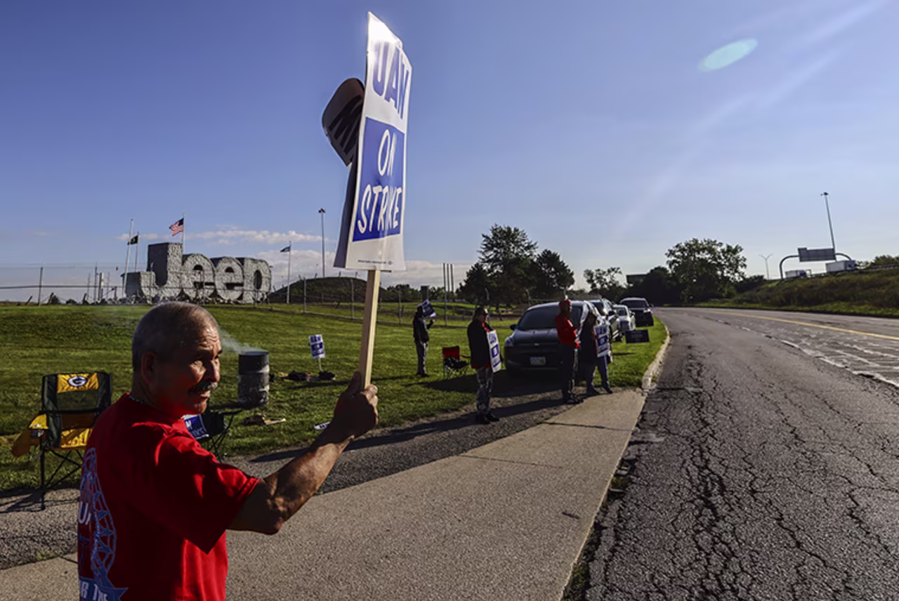 United Auto Workers hold a sign while on strike today at the Stellantis Toledo Assembly Complex in Toledo, Ohio. 