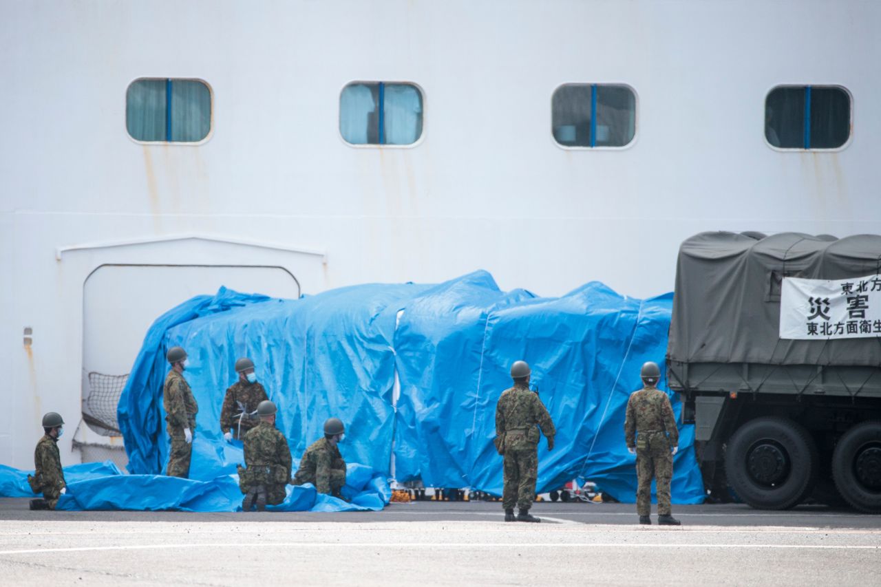 Members of the Japan Self-Defense Forces attach a military vehicle to a gate of the Diamond Princess cruise ship.