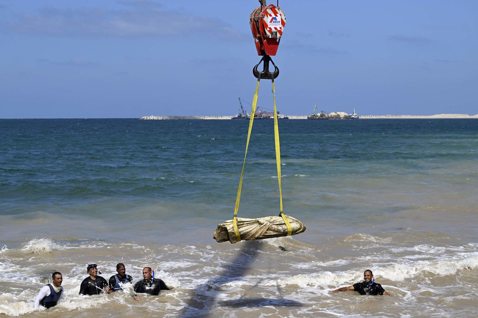 Divers watch as a crane pulls an artifact from the Abu Qir Bay in Alexandria, Egypt, on Thursday, August 21. It was part of an event to recover sunken antiquities.