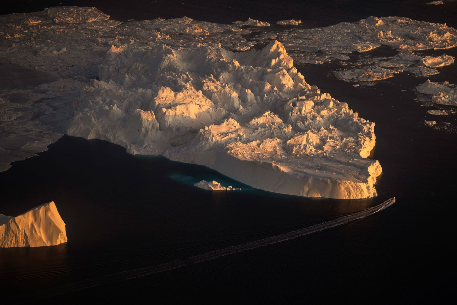 A ship sails near a large iceberg in Ilulissat, Greenland, on Tuesday, February 18.