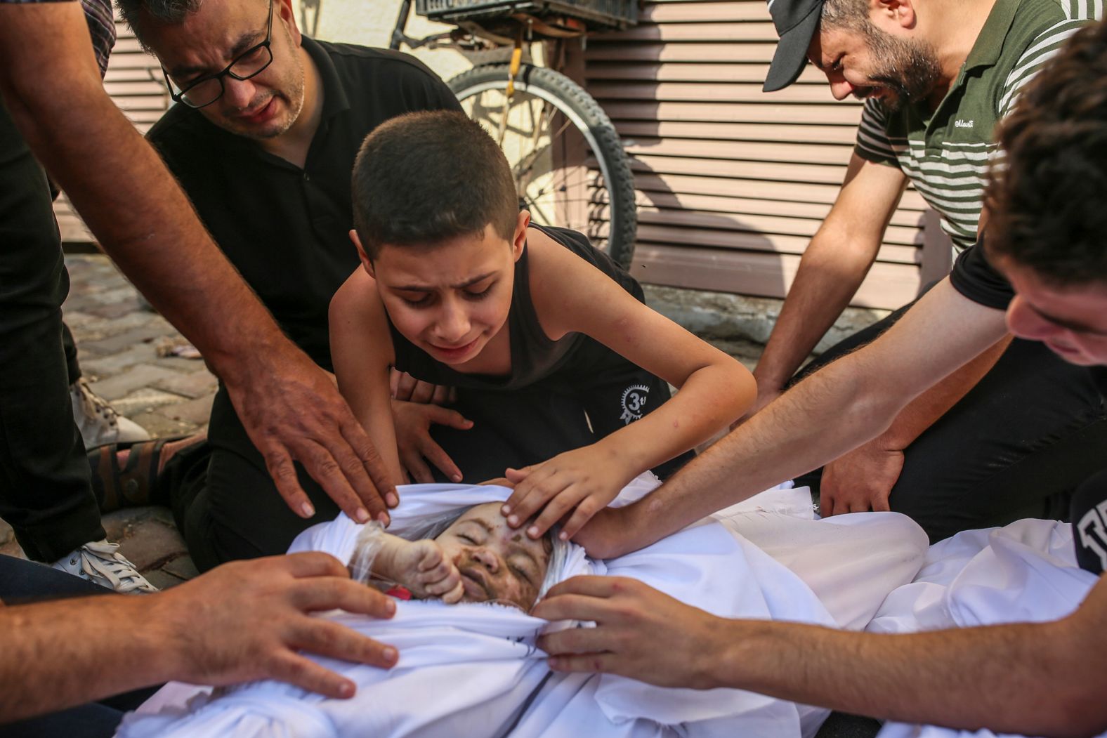 Khaled Joudeh mourns his younger sister, Misq, at the morgue of the Deir al-Balah hospital in Gaza on October 22. His mother, father, brother and sister were all killed in an Israeli airstrike. Months later, <a href="https://www.nytimes.com/2024/08/17/world/middleeast/there-is-no-childhood-in-gaza.html" target="_blank">the New York Times reported</a> Khaled was also killed in another airstrike.