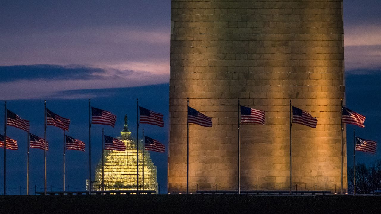 The U.S. Capitol is seen behind the Washington Monument as day breaks on Thursday, December 31.