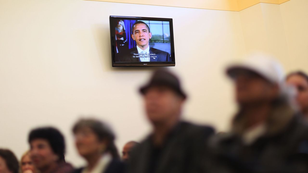 President Barack Obama is seen on a television screen congratulating people in Miami who had just been sworn in as naturalized U.S. citizens on Tuesday, December 29.