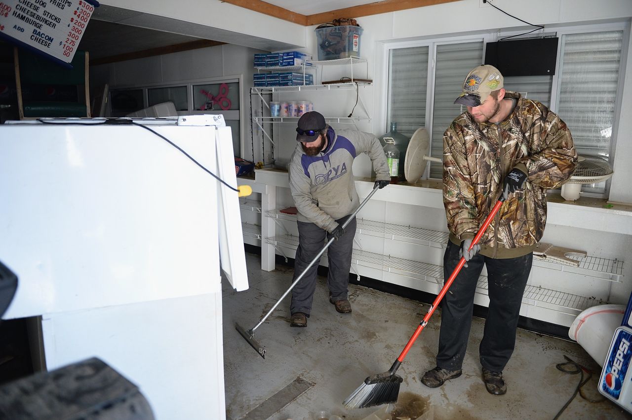 Matt Gerling, left, and Shane Menetzke clean debris from the concession stand of the Pacific Youth Assocation sports complex on January 1 in Pacific, Missouri.