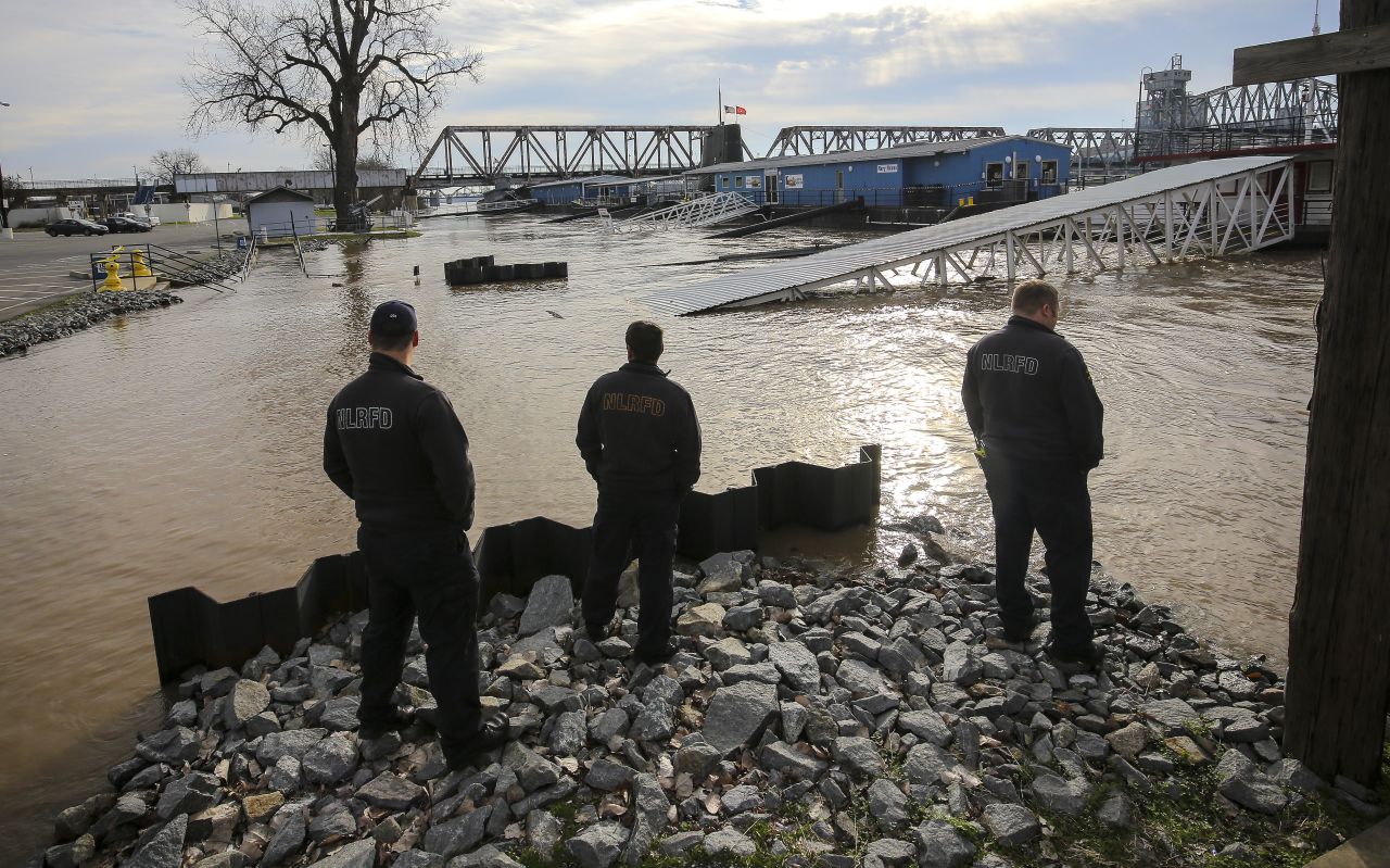 North Little Rock, Arkansas, firefighters look at the Arkansas River as it threatens a parking lot on January 1. 