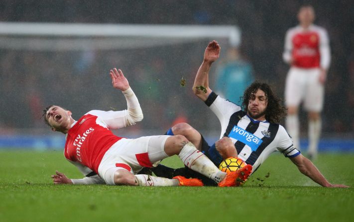 Aaron Ramsey and Fabricio Coloccini (R) compete for the ball in what was a keenly contested match.