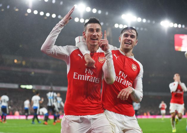 Laurent Koscielny (L) of Arsenal celebrates scoring against Newcastle United with team mate Aaron Ramsey (R).