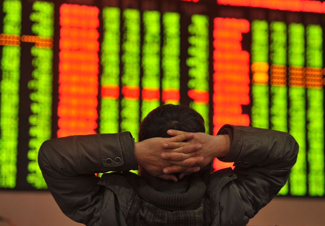 An investor sits in front of a screen showing stock market movements in a stock firm in Fuyang, east China's Anhui province.