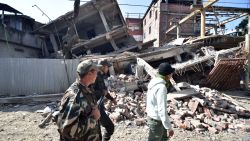 Security personel walk past a collapsed building following a 6.7 magnitude earthquake, in Imphal on December 4, 2015.  At least eight people were killed and scores injured January 4, when a strong 6.7 magnitude earthquake struck northeast India, sending panicked residents fleeing into the streets even hundreds of kilometres away in Bangladesh.   AFP PHOTO/ BIJU BORO / AFP / BIJU BORO        (Photo credit should read BIJU BORO/AFP/Getty Images)