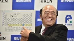 Kosuke Morita, the leader of the Riken team, smiles as he points to a board displaying the new atomic element 113 during a press conference in Wako, Saitama prefecture on December 31, 2015.  A Japanese research team has received naming rights for new atomic element 113, the first on the periodic chart to be named by Asian scientists, the team's institute said December 31. Japan's Riken Institute said a team led by Kosuke Morita was awarded the rights from global scientific bodies -- the International Union of Pure and Applied Chemistry (IUPAC) and the International Union of Pure and Applied Physics (IUPAP) -- after successfully creating the new synthetic element three times from 2004 to 2012.    AFP PHOTO / KAZUHIRO NOGI / AFP / KAZUHIRO NOGI        (Photo credit should read KAZUHIRO NOGI/AFP/Getty Images)