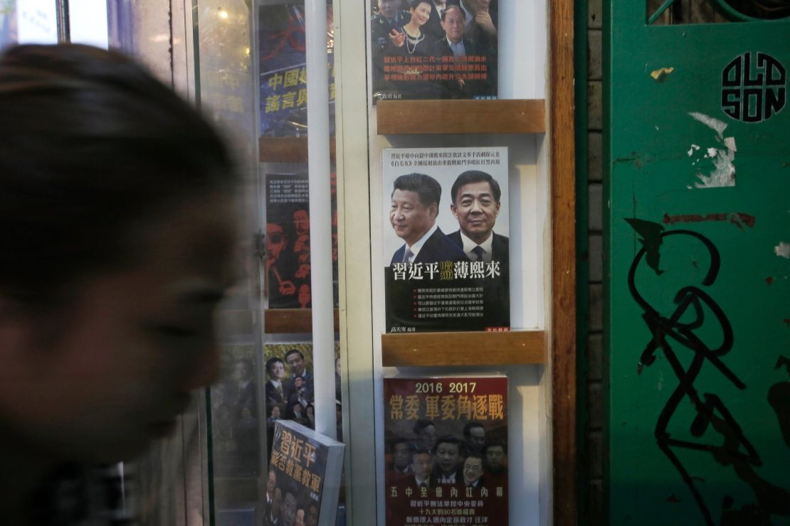 A woman walks past a book featuring a photo of Chinese President Xi Jinping, left, and former Politburo member and Chongqing city party leader Bo Xilai on the cover, at the entrance of the closed Causeway Bay Bookstore, Sunday, January 3, 2016.