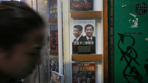 A woman walks past a book featuring a photo of Chinese President Xi Jinping, left, and former Politburo member and Chongqing city party leader Bo Xilai on the cover, at the entrance of the closed Causeway Bay Bookstore, Sunday, January 3, 2016.
