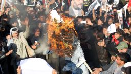 Supporters of Iraqi Shiite cleric Moqtada al-Sadr (portrait top-C) burn a effigy of a member of the Saudi ruling family as others hold posters of prominent Shiite cleric Nimr al-Nimr during a demonstration in the capital Baghdad on January 4, 2016, against Nimr's execution by Saudi authorities. Sunni-ruled Saudi Arabia severed diplomatic ties with Shiite-dominated Iran, its long-time regional rival, after angry demonstrators attacked the Saudi embassy in Tehran and its consulate following Nimr's execution. AFP PHOTO / AHMAD AL-RUBAYE / AFP / AHMAD AL-RUBAYE        (Photo credit should read AHMAD AL-RUBAYE/AFP/Getty Images)
