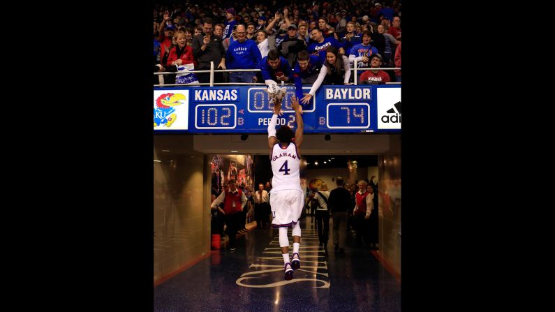 Kansas basketball player Devonte' Graham high-fives fans after a home win over Baylor on Saturday, January 2.