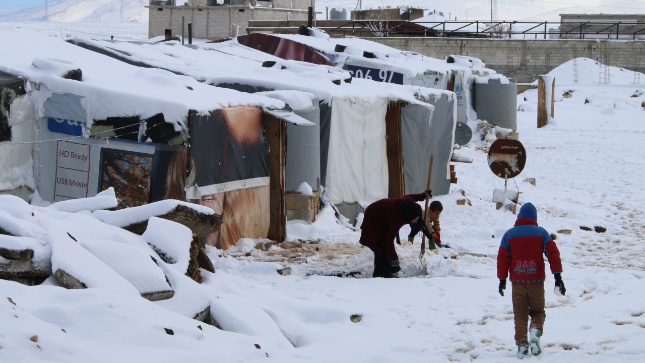 Syrian refugees walk in a makeshift camp in Lebanon last year. 