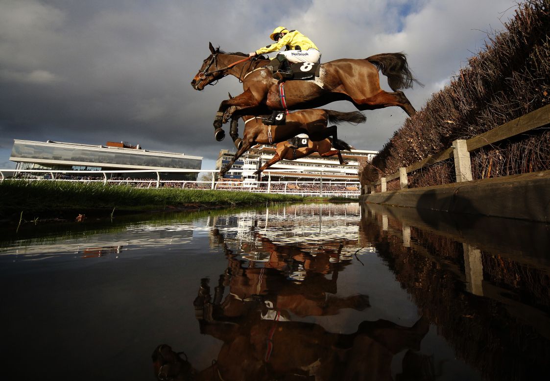 Horses clear a water jump during a steeplechase race in Newbury, England, on Tuesday, December 29.
