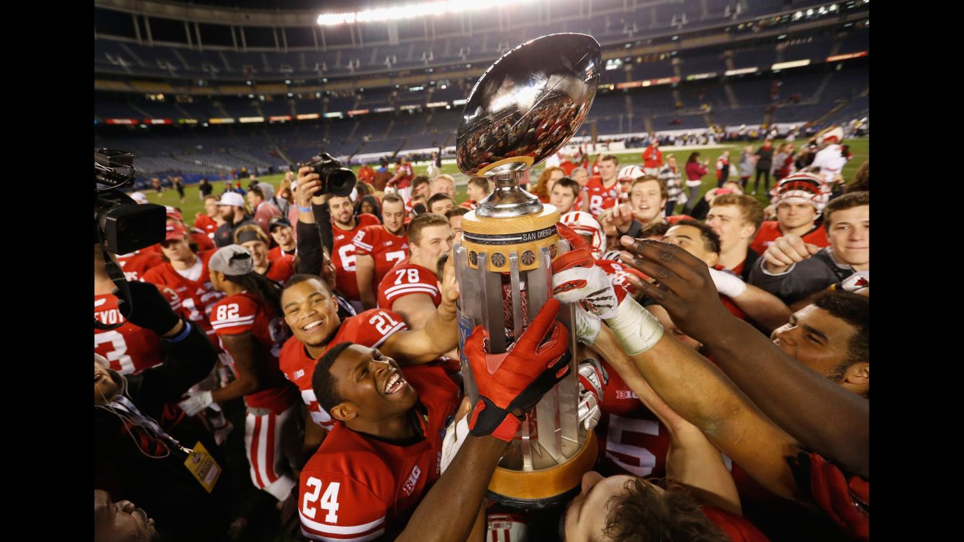 Wisconsin football players hold up the Holiday Bowl trophy after defeating USC on Wednesday, December 30.